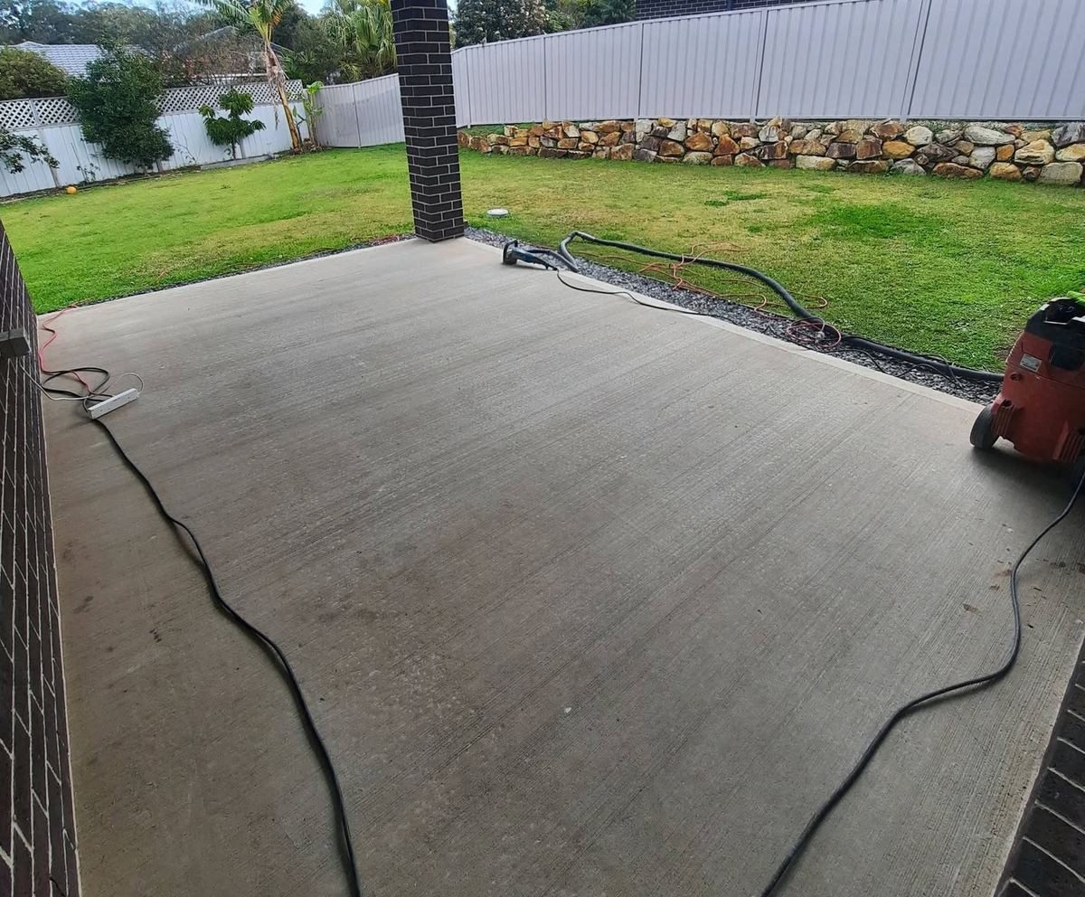 Floor Candy grinding a concrete driveway with dust extraction running
